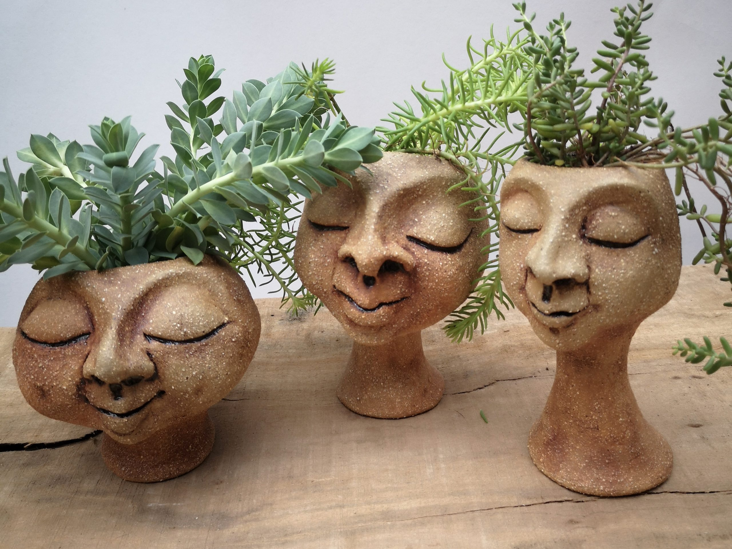 Hand sculpted clay head planter pots, Each one quirky and original.